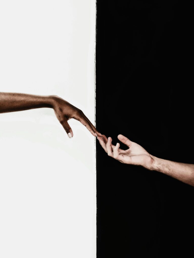 pexels-photo-3541916-3541916 Symbolic image of two hands reaching toward each other, representing unity and diversity.